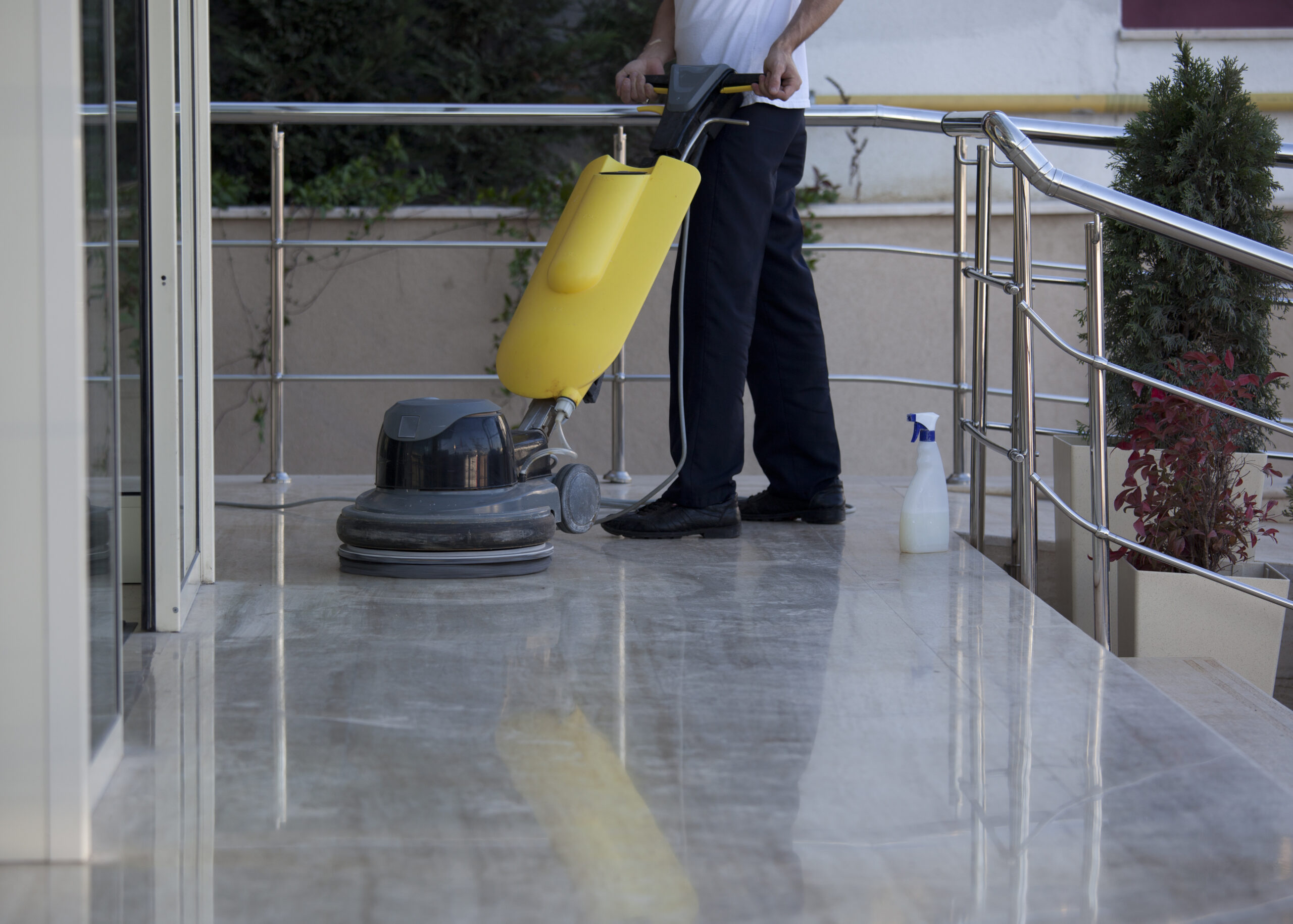 cleaner is cleaning floor with a machine